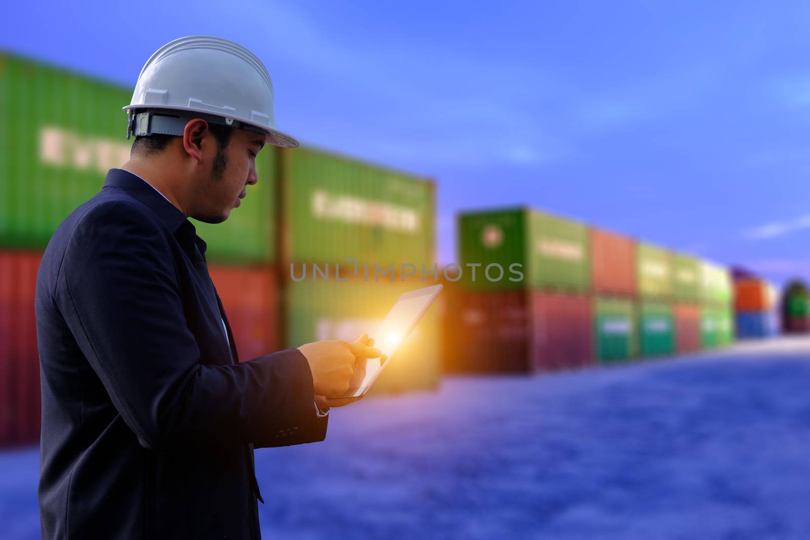 The engineer is working with tabet on containers background. by 0864713049
