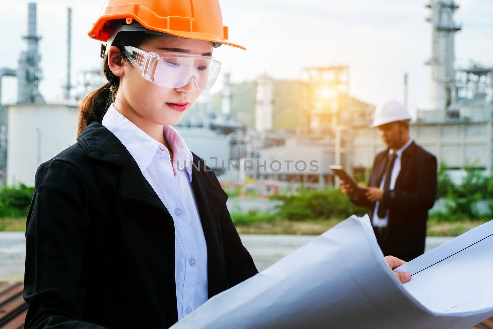 The engineer is checking a layout on large industry background. The construction manager on the industry background.
