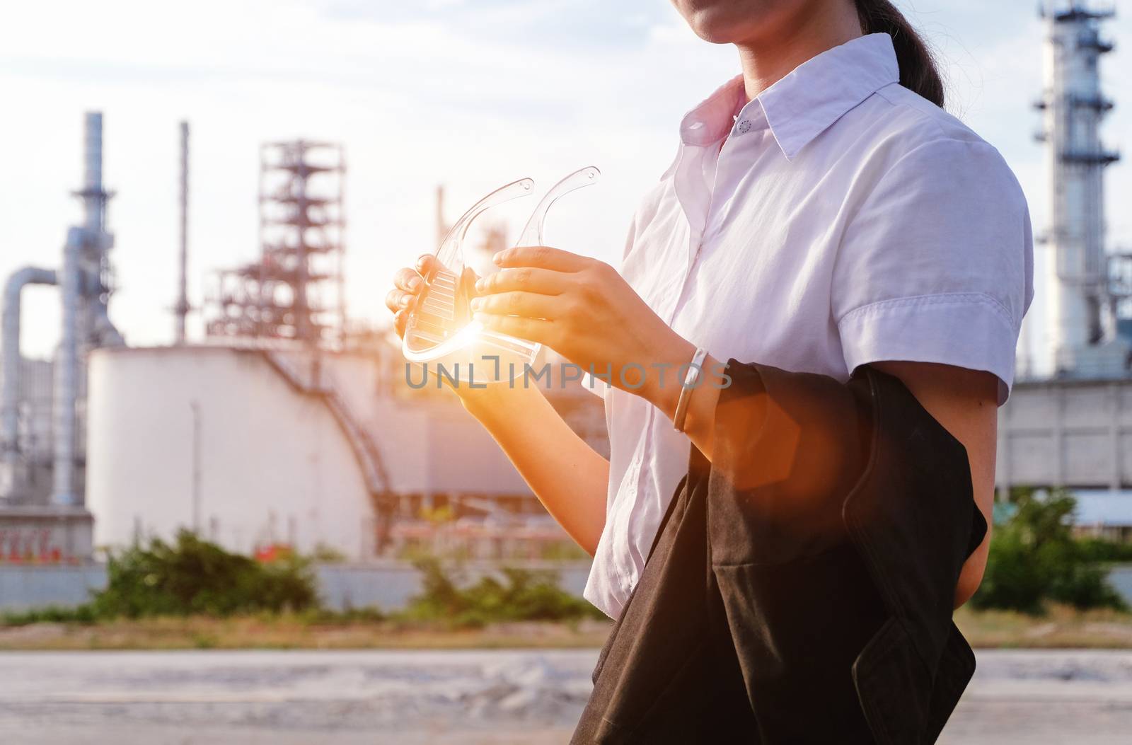 The engineer is standing on large industry background. The construction manager on the industry background.