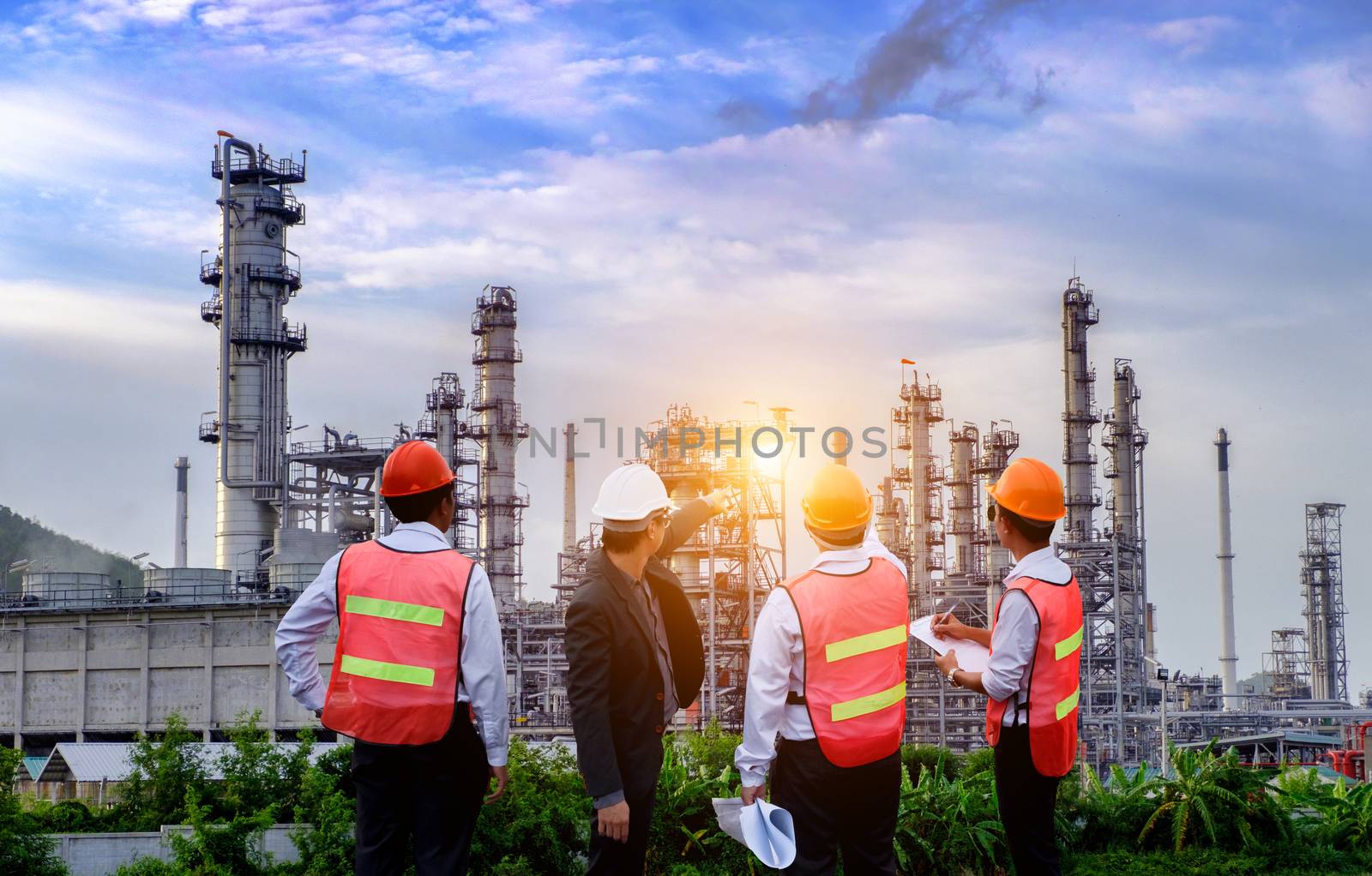 The engineers are standing on large industry background. by 0864713049