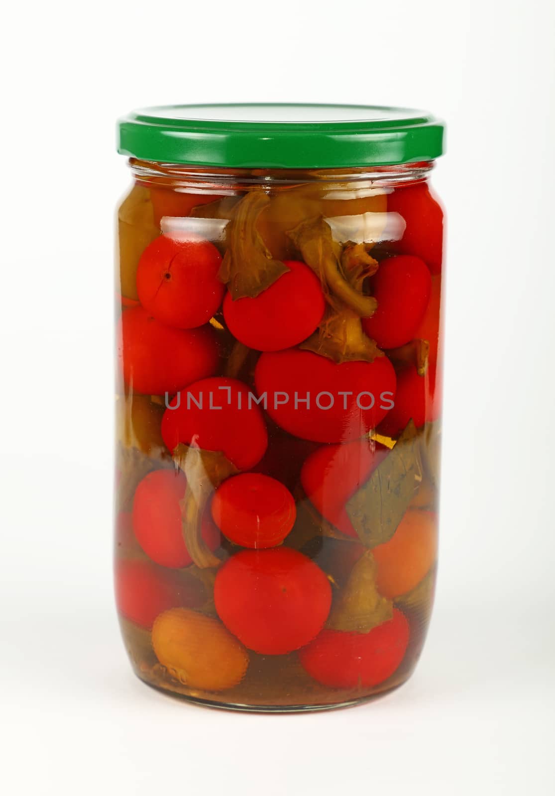 Jar of pickled red hot chili peppers over white by BreakingTheWalls