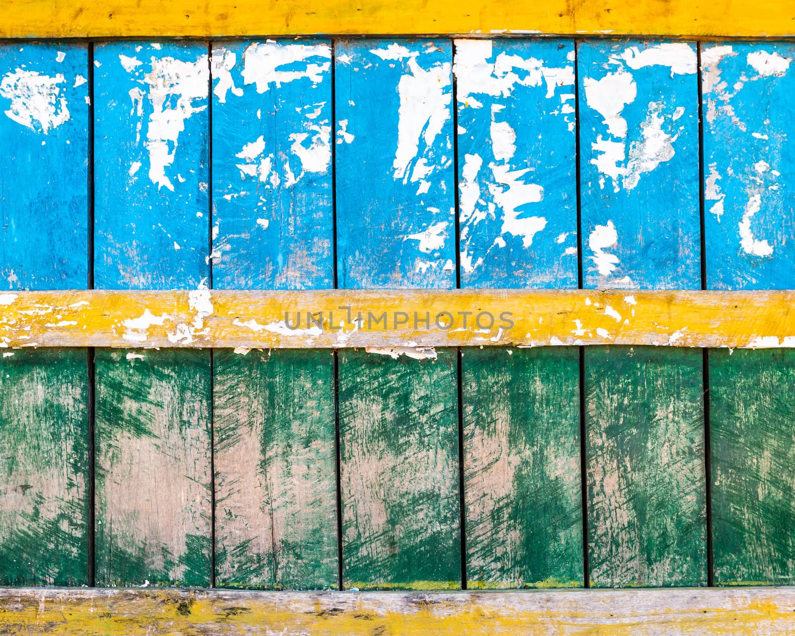 Grungy blue, green and yellow wood wall texture, torn paper in the top half