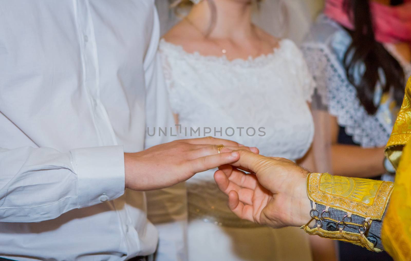 Priest placing wedding ring to groom by Angel_a