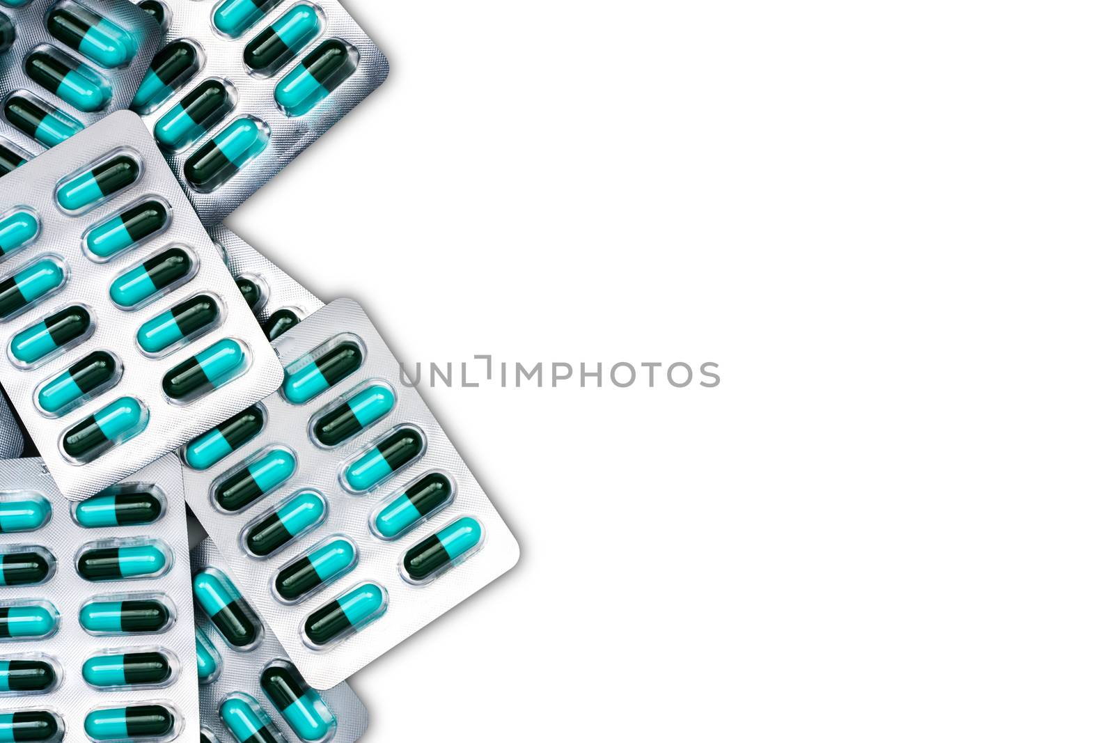 Top view of blue and green antibiotics capsule pills in blister packs isolated on white background with copy space. Antimicrobial drug resistance and antibiotics drug use with reasonable concept. Pharmaceutical industry. Pharmacy background. Global healthcare concept.