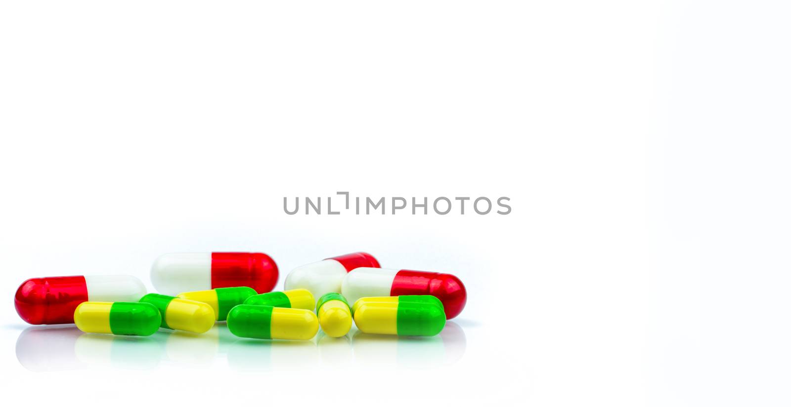 Colorful of capsule pills on white background with copy space for text. Pharmacology and drug interactions concept. Pharmaceutical industry. Pharmacy background. Global healthcare concept. by Fahroni