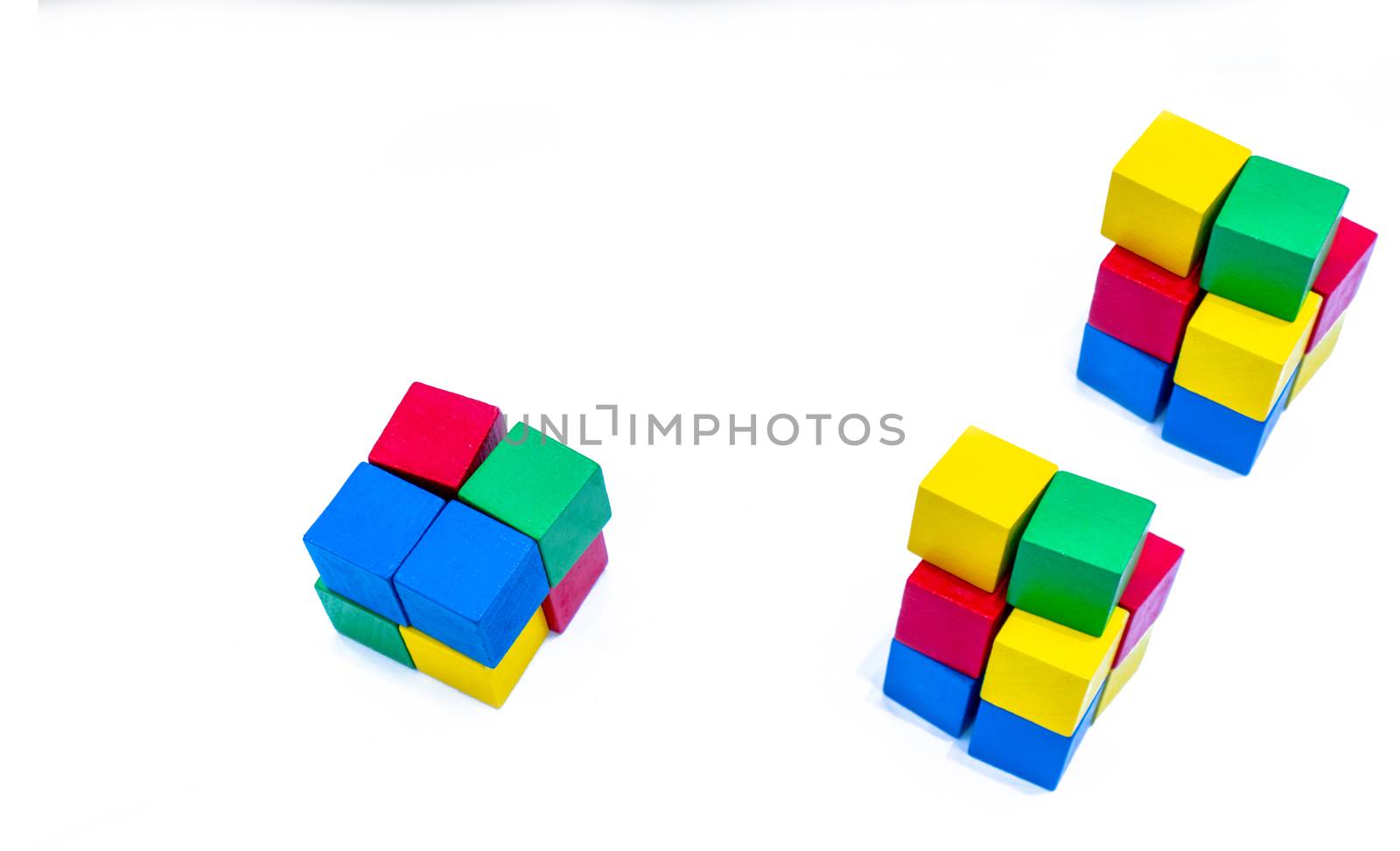 Stack of bright color wooden building block isolated on white background. Blue, red, green, and yellow cube blocks. Kids, baby and child toy help boost fine motor skills and small muscle development by Fahroni