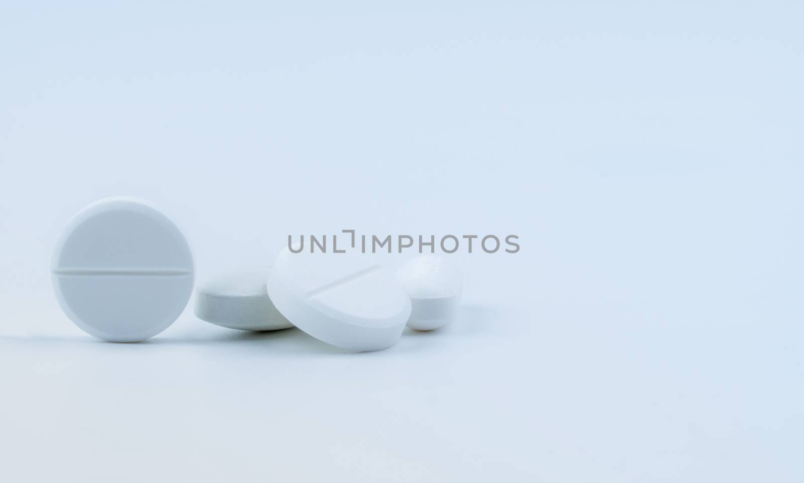 Pile of white round tablet pills isolated on white background. Pharmaceutical industry. Pharmacy or drugstore sign and symbol. Global healthcare concept. Health and pharmacology.