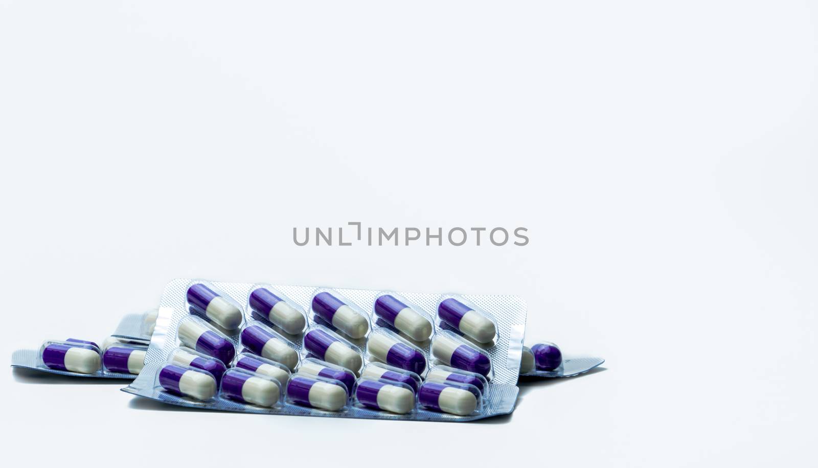 Fluconazole : Antifungal medicine. Heap of pills in blister packs on white background. Healthcare concept. Medicine pills can cause liver damage. Pharmaceutical industry background. by Fahroni