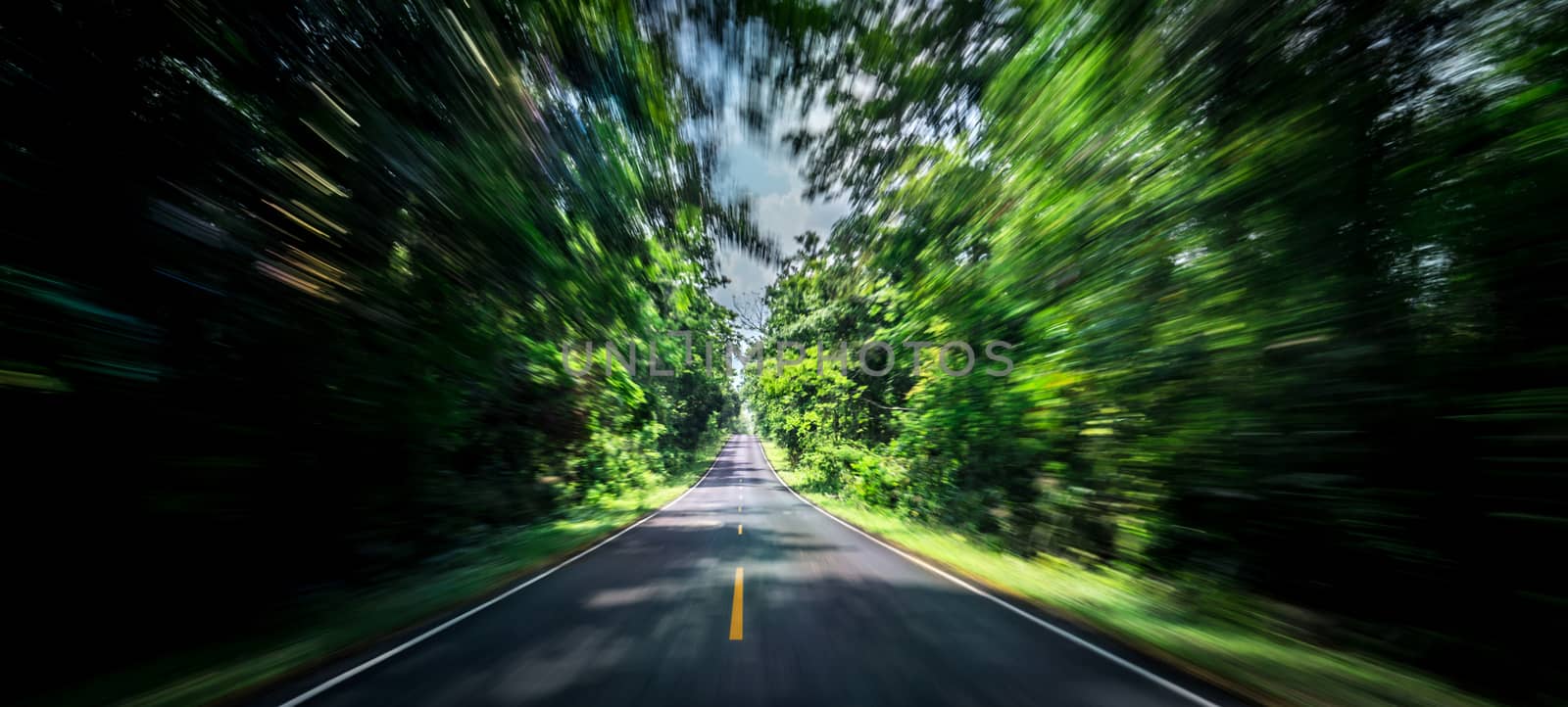 Empty asphalt road and speed motion blur on highway in summer with green trees forest at countryside by Fahroni