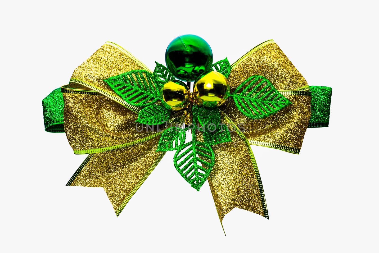 Shiny green and gold Christmas bow and ball isolated on white background with copy space. Ribbon for gift or present concept. Christmas decorative ribbon and Christmas ornament concept.