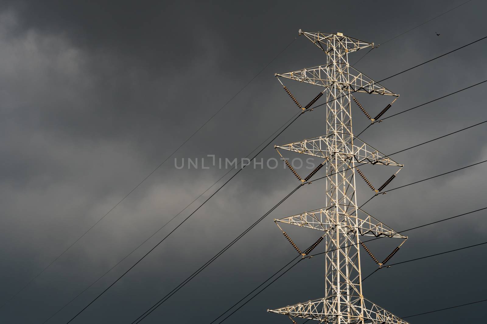 High voltage tower with electric cable and dark sky. Power and energy industry. Despair and hopeless concept.