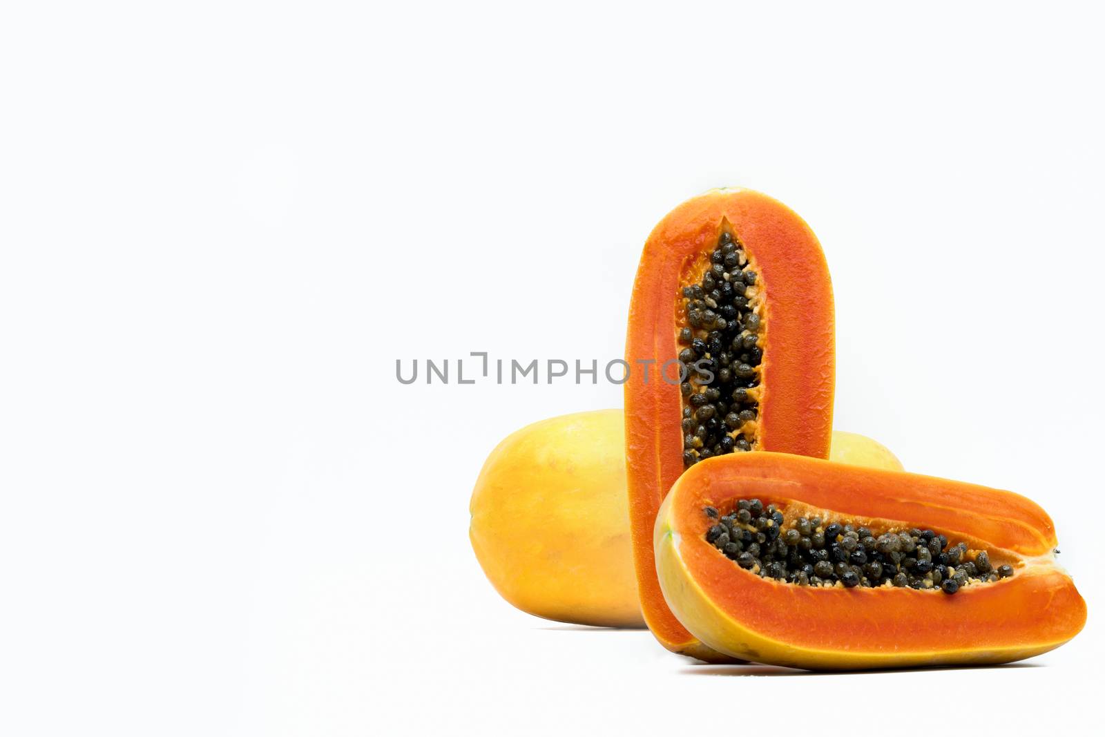 Whole and half of ripe papaya fruit with seeds isolated on white background with copy space. Natural source of vitamin C, folate and minerals. Healthy food for pregnant and breast feeding woman