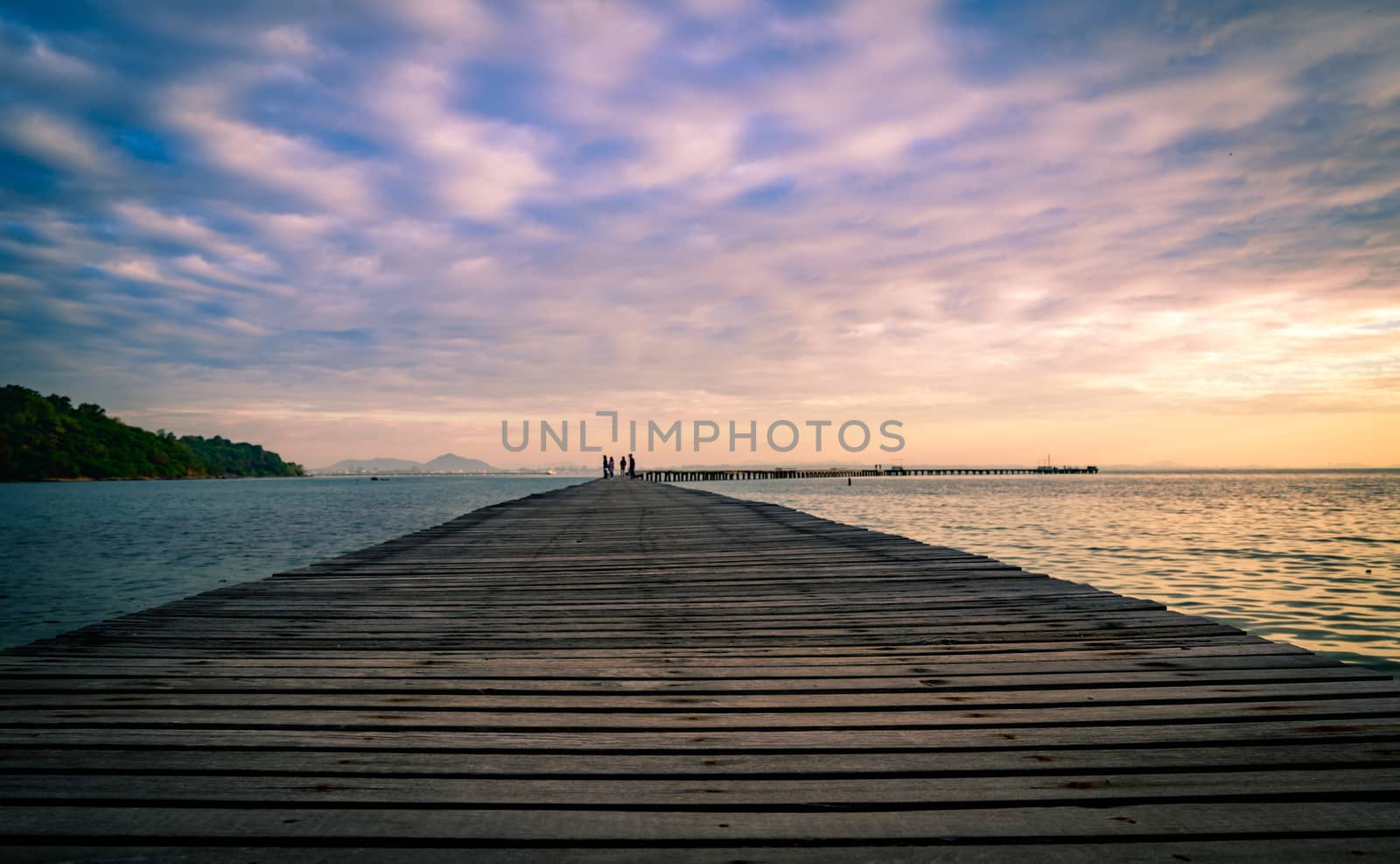 Wood bridge pier with beautiful sunrise sky and clouds in the morning use for natural background. Tourist walk on wooden pier to the sea by Fahroni