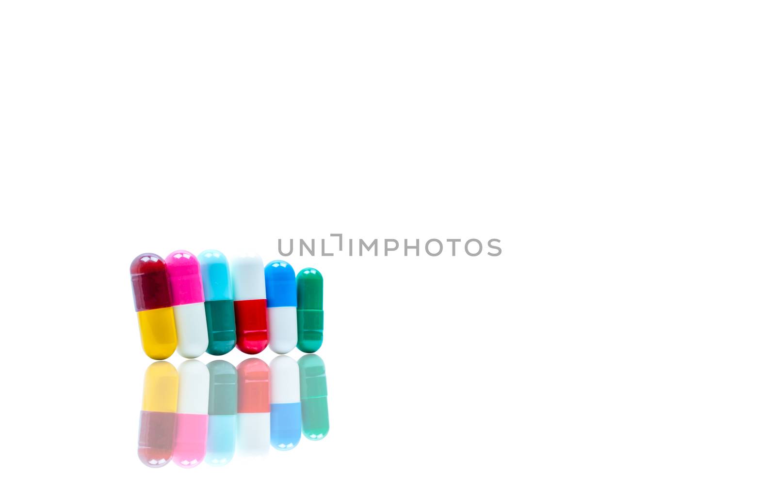 Antibiotic capsules pills in a row on white background with shadows and copy space. Drug resistance concept. Antibiotics drug use with reasonable and global healthcare concept. Pharmaceutical industry. Pharmacy background. Health budgets and policy.