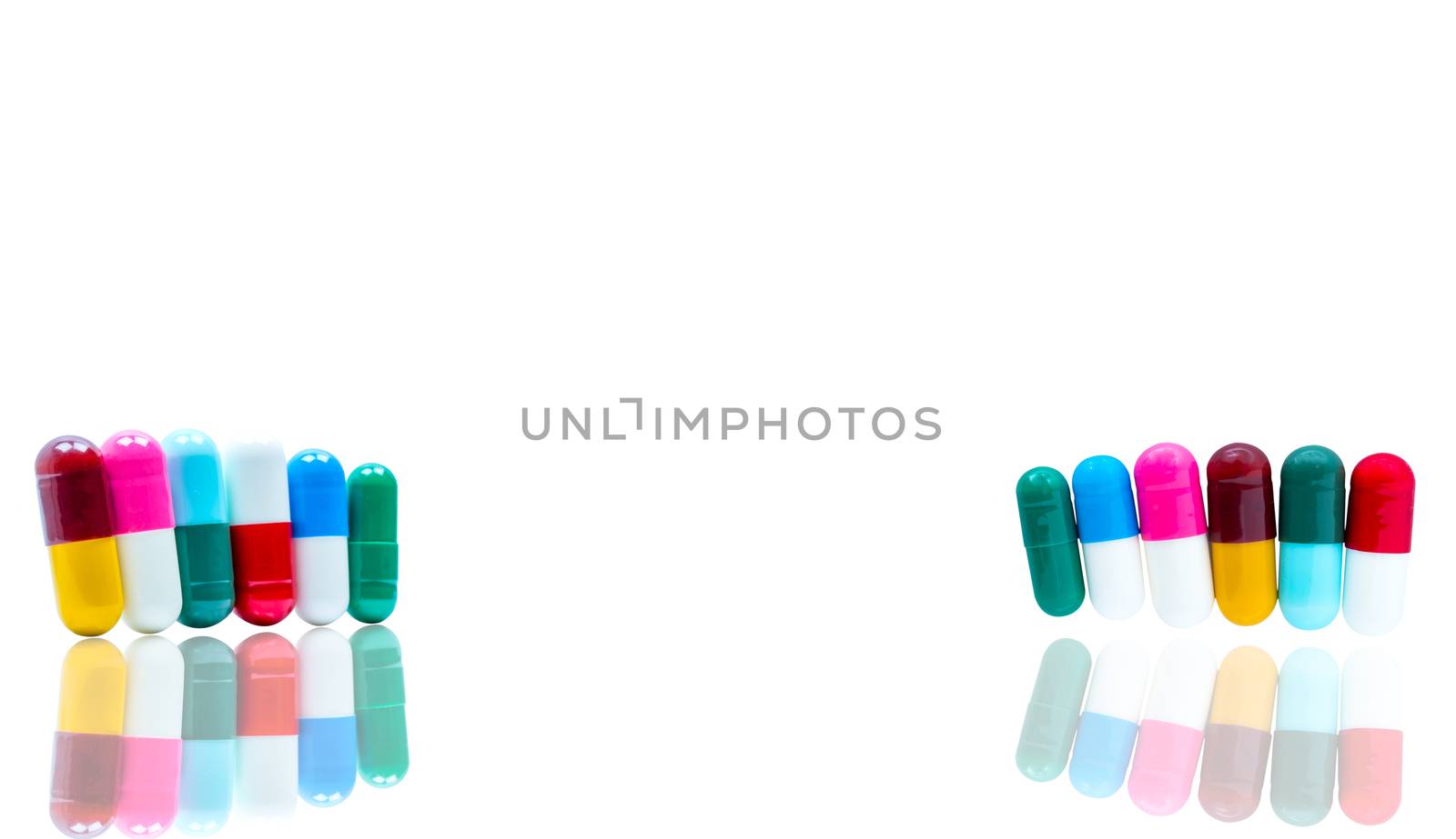 Antibiotic capsules pills in a row on white background with shadows and copy space. Drug resistance concept. Antibiotics drug use with reasonable and global healthcare concept. Pharmaceutical industry. Pharmacy background. Health budgets and policy. by Fahroni