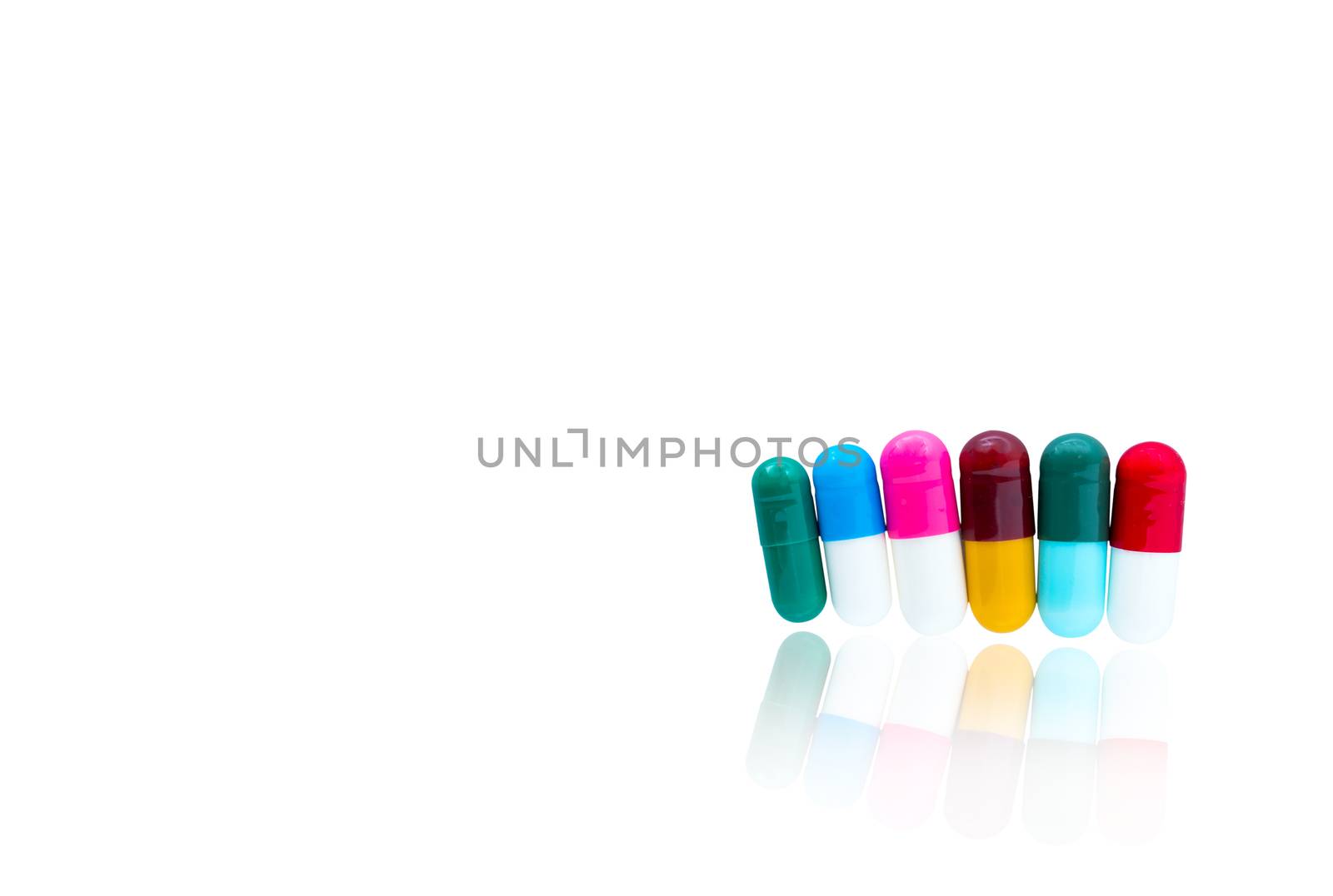 Antibiotic capsules pills in a row on white background with shadows and copy space. Drug resistance concept. Antibiotics drug use with reasonable and global healthcare concept. Pharmaceutical industry. Pharmacy background. Health budgets and policy.