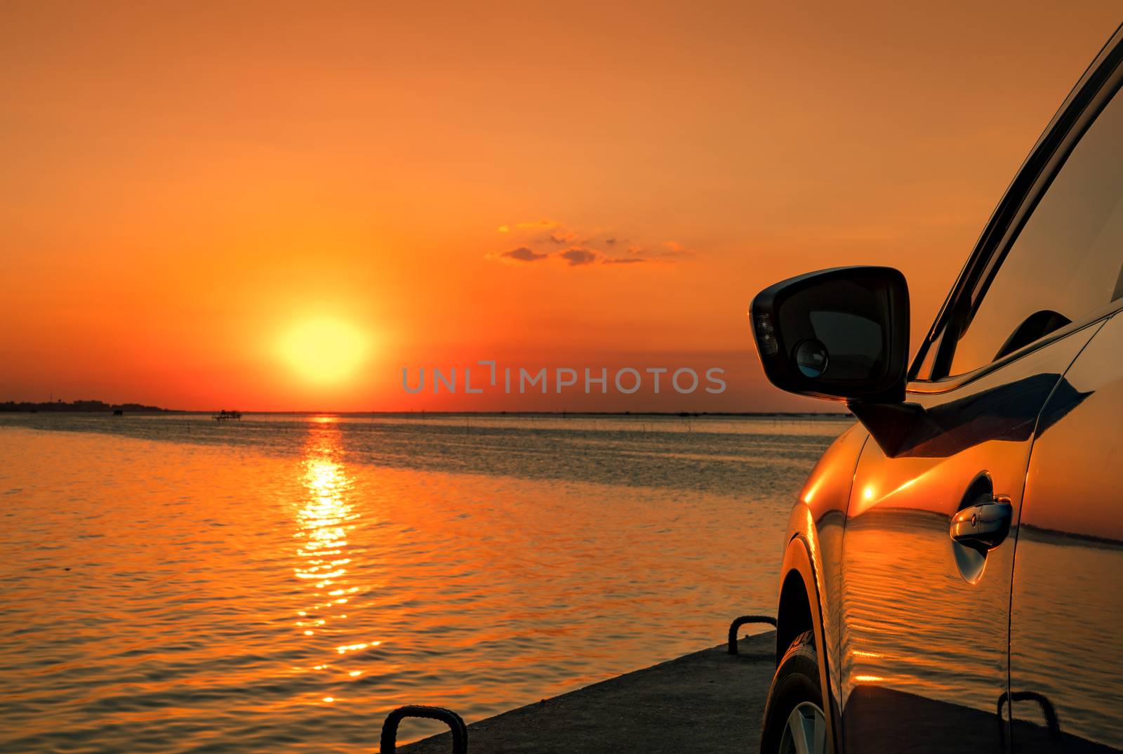 Blue compact SUV car with sport and modern design parked on concrete road by the sea at sunset. Environmentally friendly technology. Business success concept. Hybrid car. Automotive industry. by Fahroni