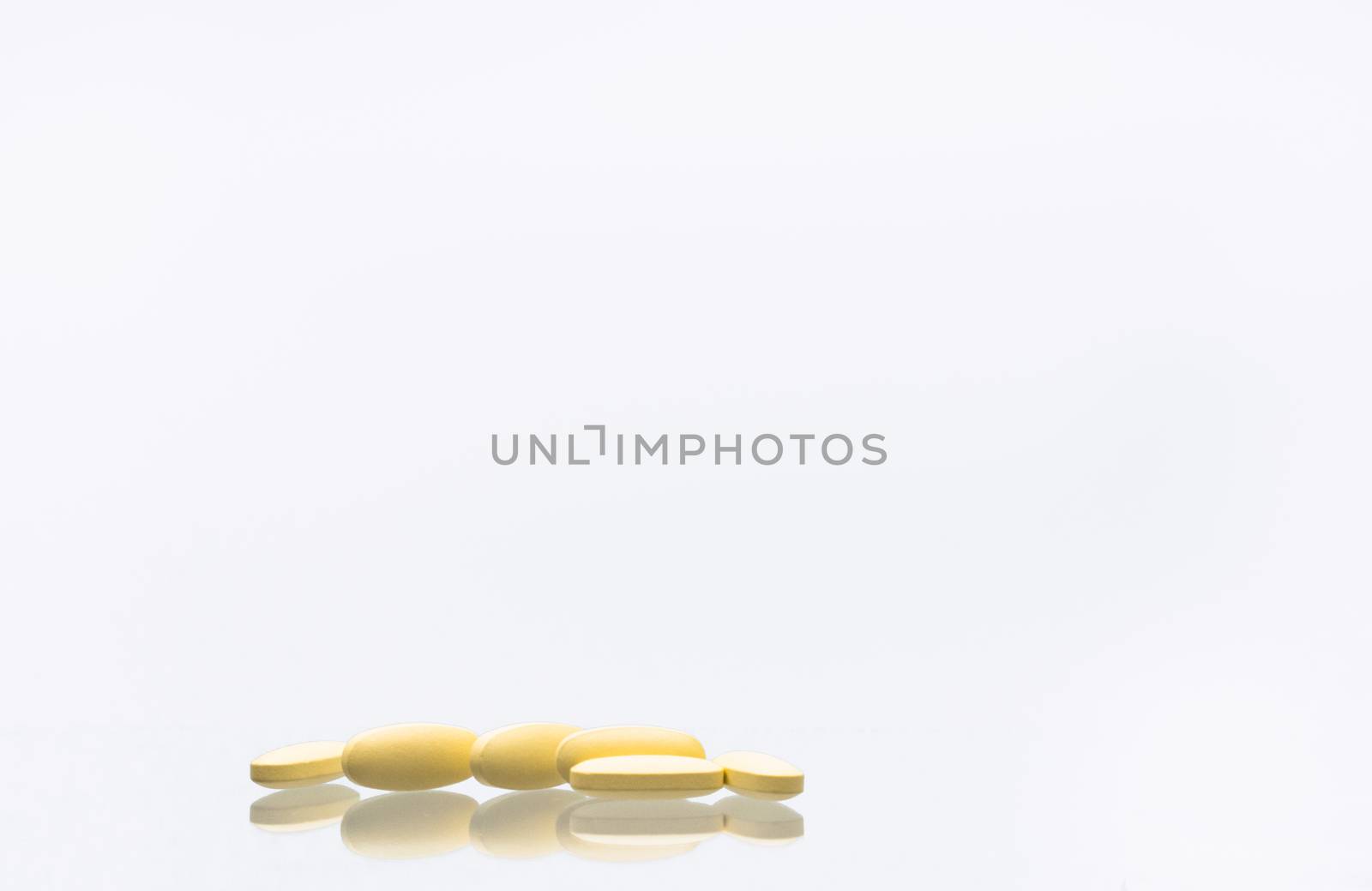 Macro shot of tablets pills of vitamin C 1,000 mg isolated on white background with shadows and copy space for text. Vitamin and supplement concept. Antioxidants. Pharmaceutical industry. Pharmacy background. by Fahroni
