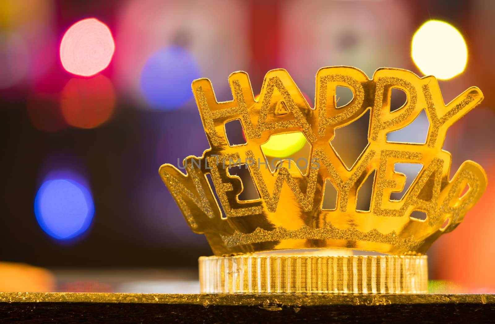 Golden Happy New Year headband on colorful bokeh background by Fahroni