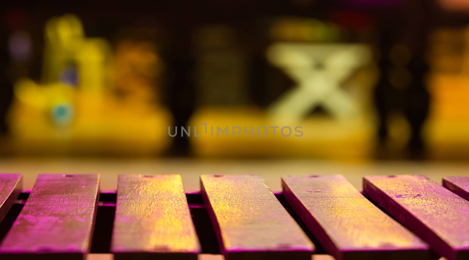 Empty wood bench on blur background with night light.