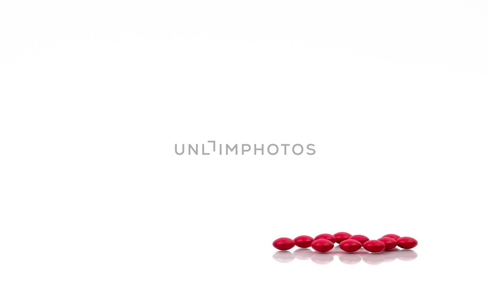 Red pills isolated on white background with copy space for text and clipping path. Global healthcare concept. Vitamin B Complex for convalescent and geriatric patients and peripheral neuritis.