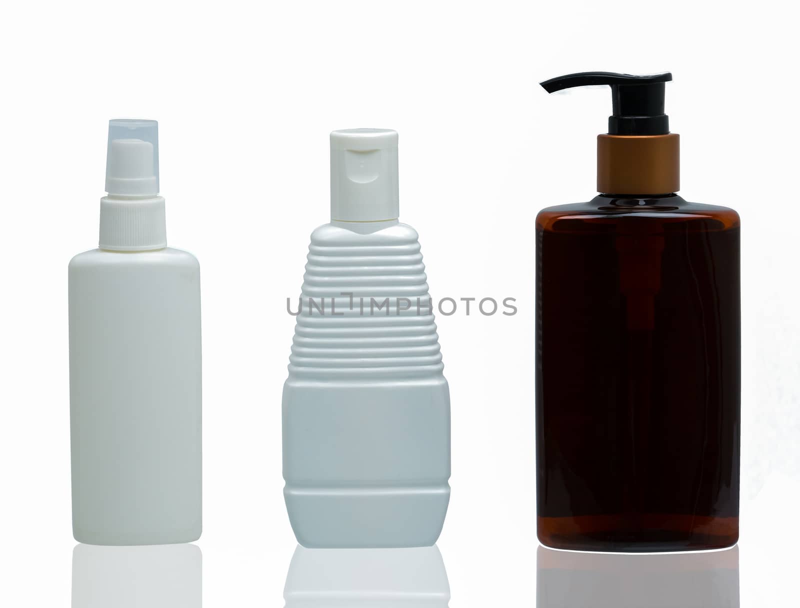 Three white and brown plastic cosmetic bottles with different type of cap : pump, spray and cap isolated on the white background with blank label and copy space by Fahroni