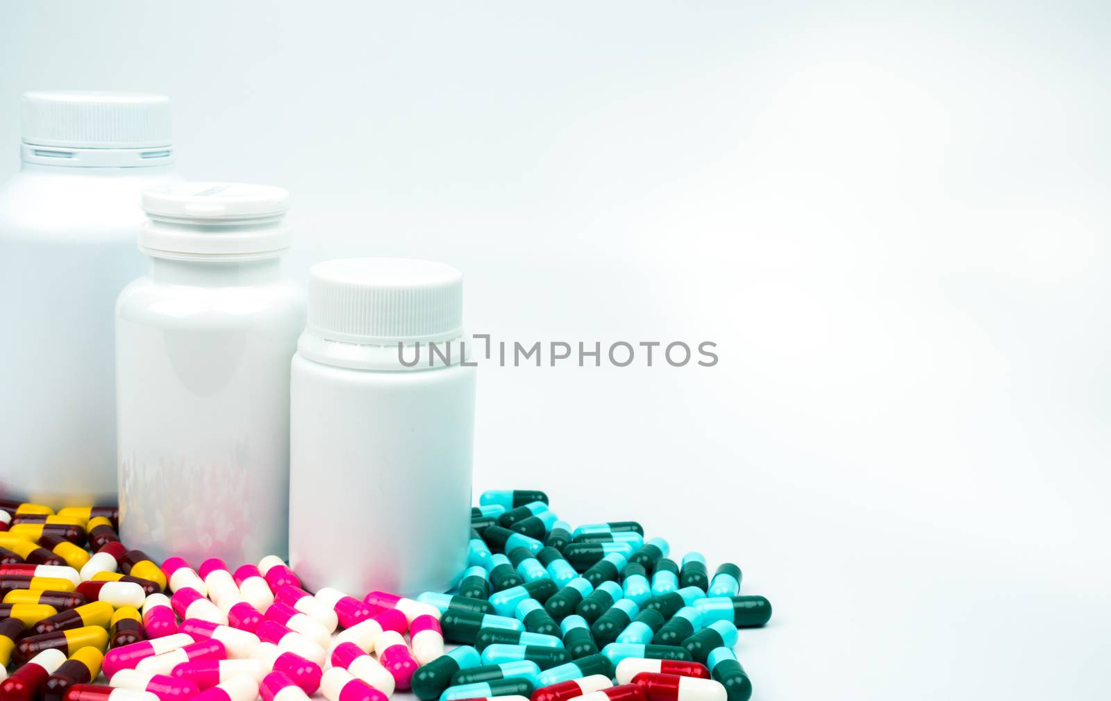 Antibiotic capsules pills and plastic bottle with blank label isolated on white background with copy space. Drug resistance concept. Antibiotics drug use with reasonable and global healthcare concept. Pharmaceutical industry. Health budgets and policy. by Fahroni