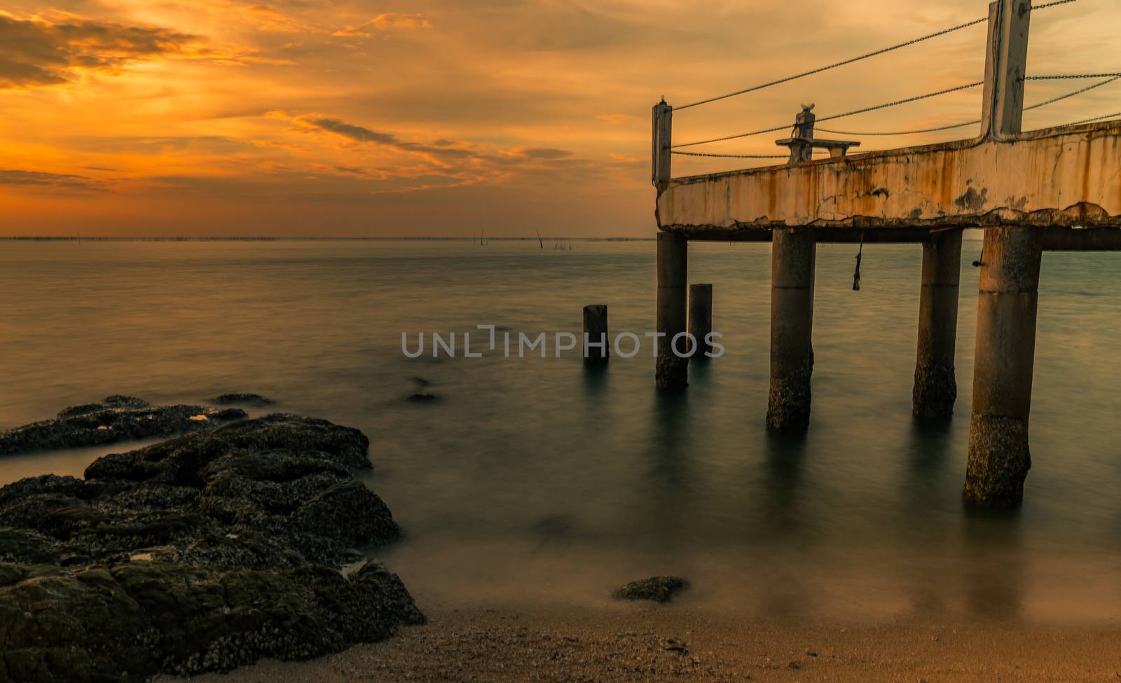 A long exposure landscape of beautiful sunset at the sea beach n by Fahroni