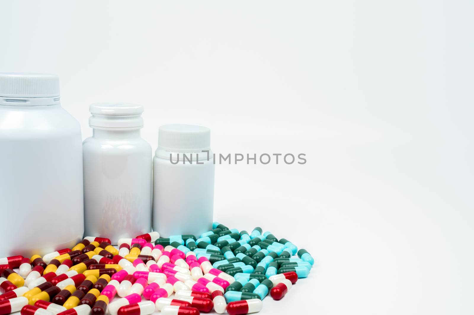 Antibiotic capsules pills and plastic bottle with blank label isolated on white background with copy space. Drug resistance concept. Antibiotics drug use with reasonable and global healthcare concept. Pharmaceutical industry. Health budgets and policy.
