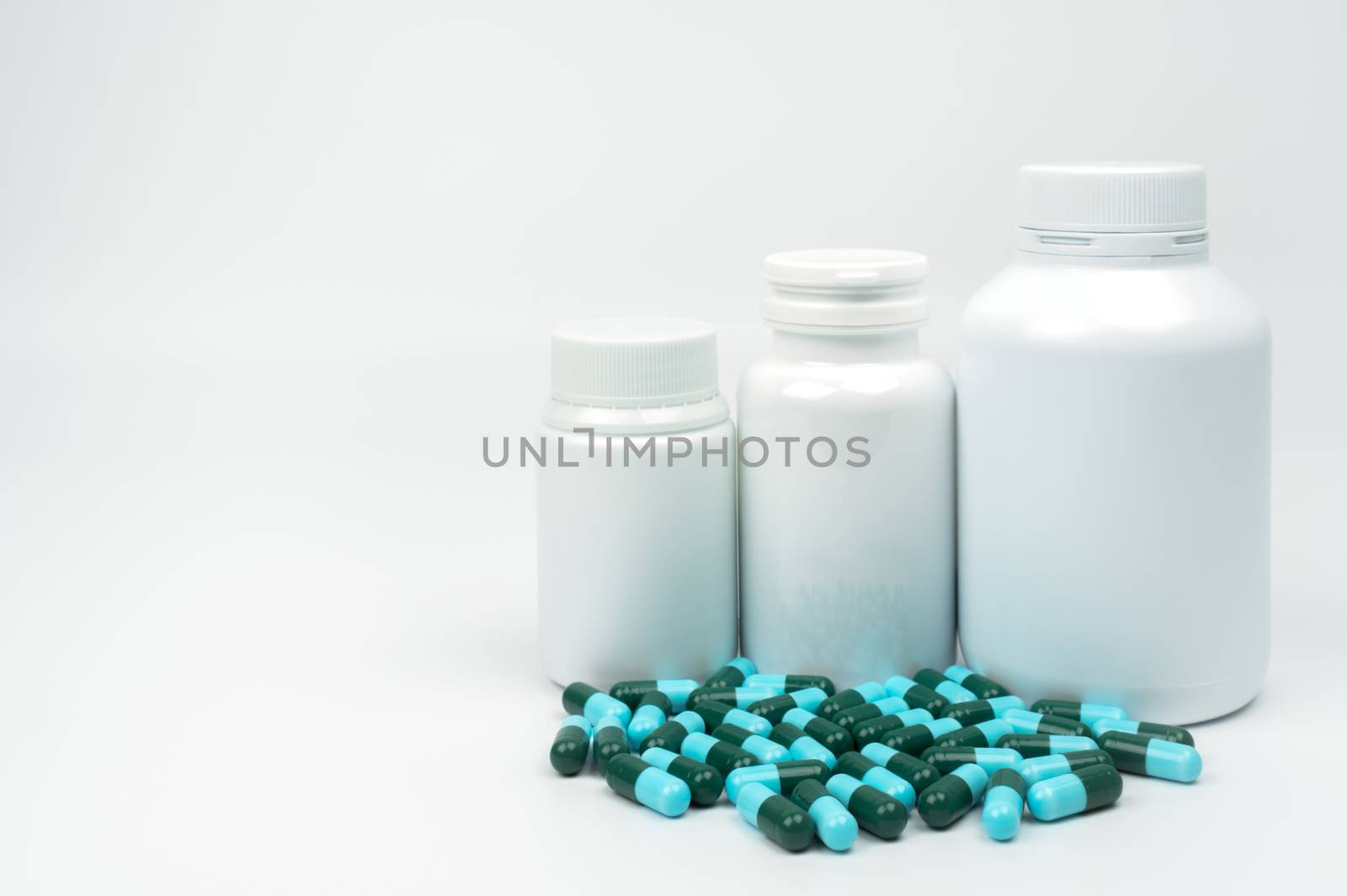 Antibiotic capsule pills and plastic bottle with blank label isolated on white background with copy space. Drug resistance concept. Antibiotics drug use with reasonable and global healthcare concept. Pharmaceutical industry. Pharmacy background. Health budgets and policy concept. by Fahroni