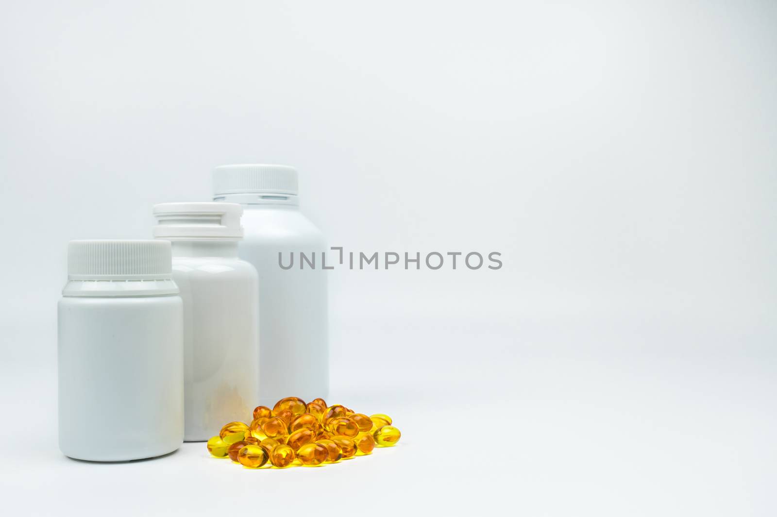 Yellow soft gelatin capsule pills with closed blank label bottle on white background with copy space, just add your own text. Use for advertise vitamin and supplement, health protection concept. Pharmaceutical industry. Pharmacy background. Global healthcare concept. by Fahroni