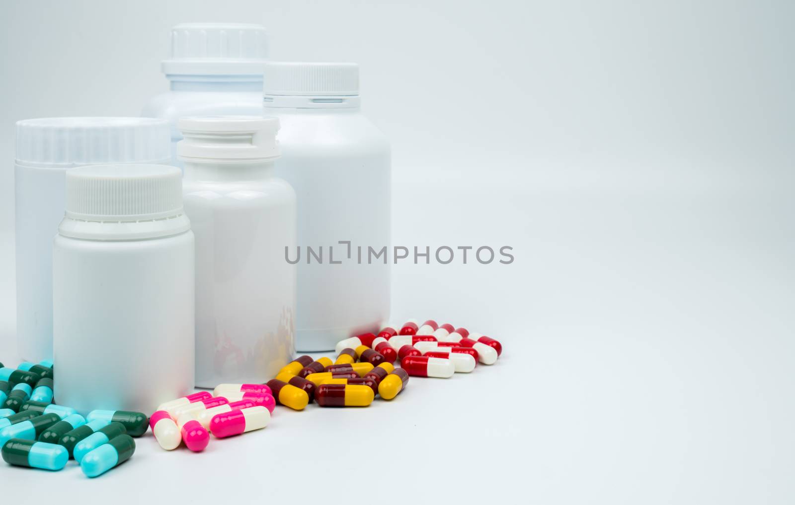 Antibiotic capsules pills and plastic bottle with blank label isolated on white background with copy space. Drug resistance concept. Antibiotics drug use with reasonable and global healthcare concept. Pharmaceutical industry. Pharmacy background. Health budgets and policy concept.