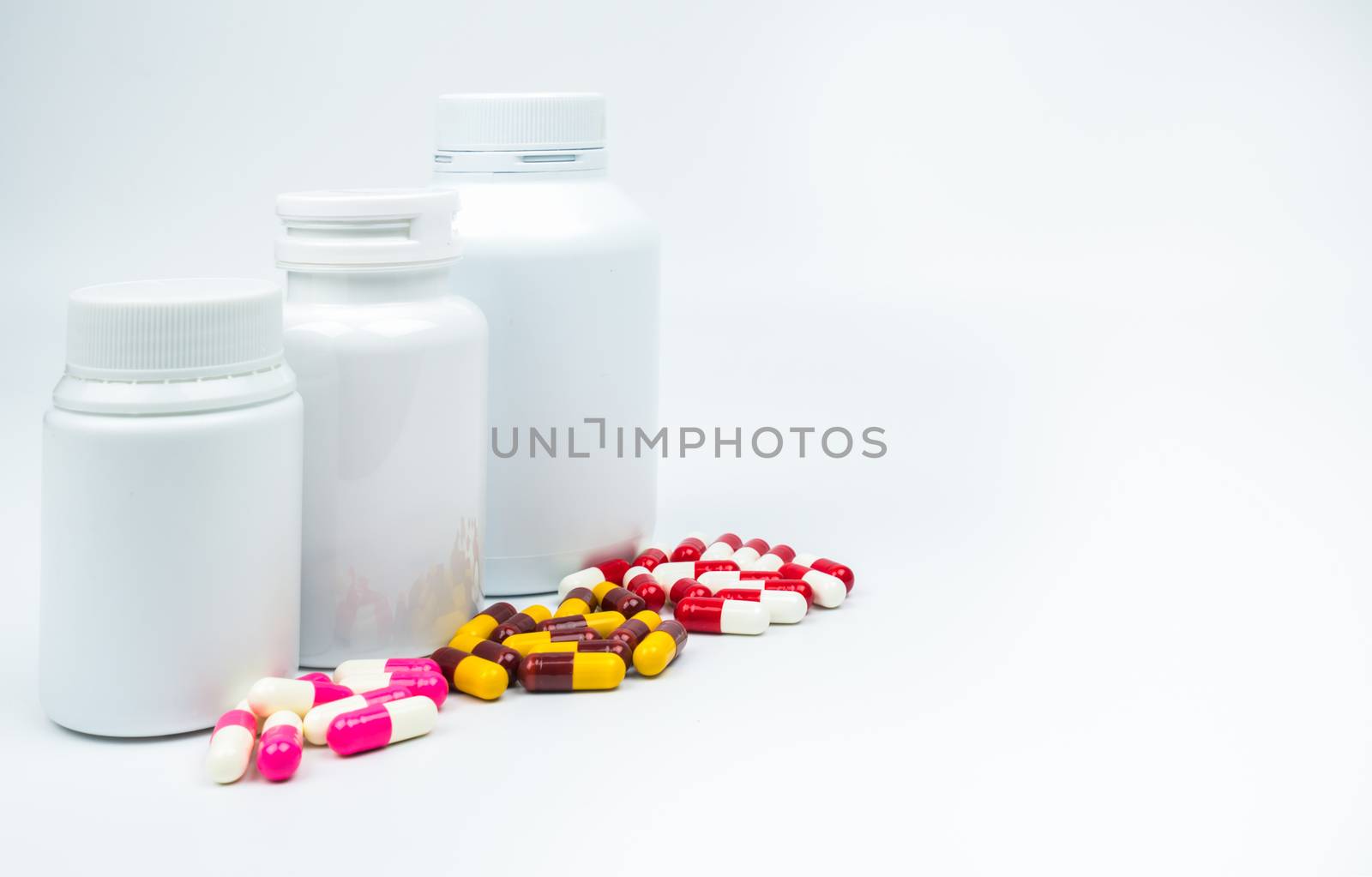 Antibiotic capsules pills and plastic bottle with blank label isolated on white background with copy space. Drug resistance concept. Antibiotics drug use with reasonable and global healthcare concept. Pharmaceutical industry. Pharmacy background. Health budgets and policy concept.