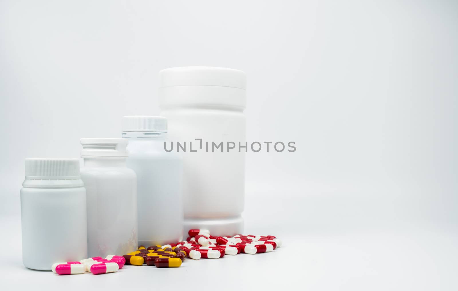 Antibiotic capsules pills and plastic bottle with blank label isolated on white background with copy space. Drug resistance concept. Antibiotics drug use with reasonable and global healthcare concept.