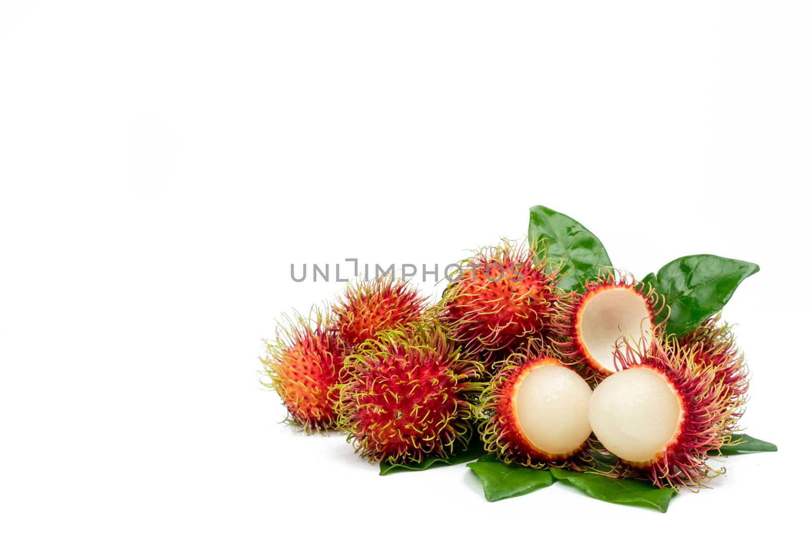 Closeup of fresh red ripe rambutan (Nephelium lappaceum) with leaves isolated on white background with clipping path. Thai dessert sweet fruits. Tropical fruit. by Fahroni