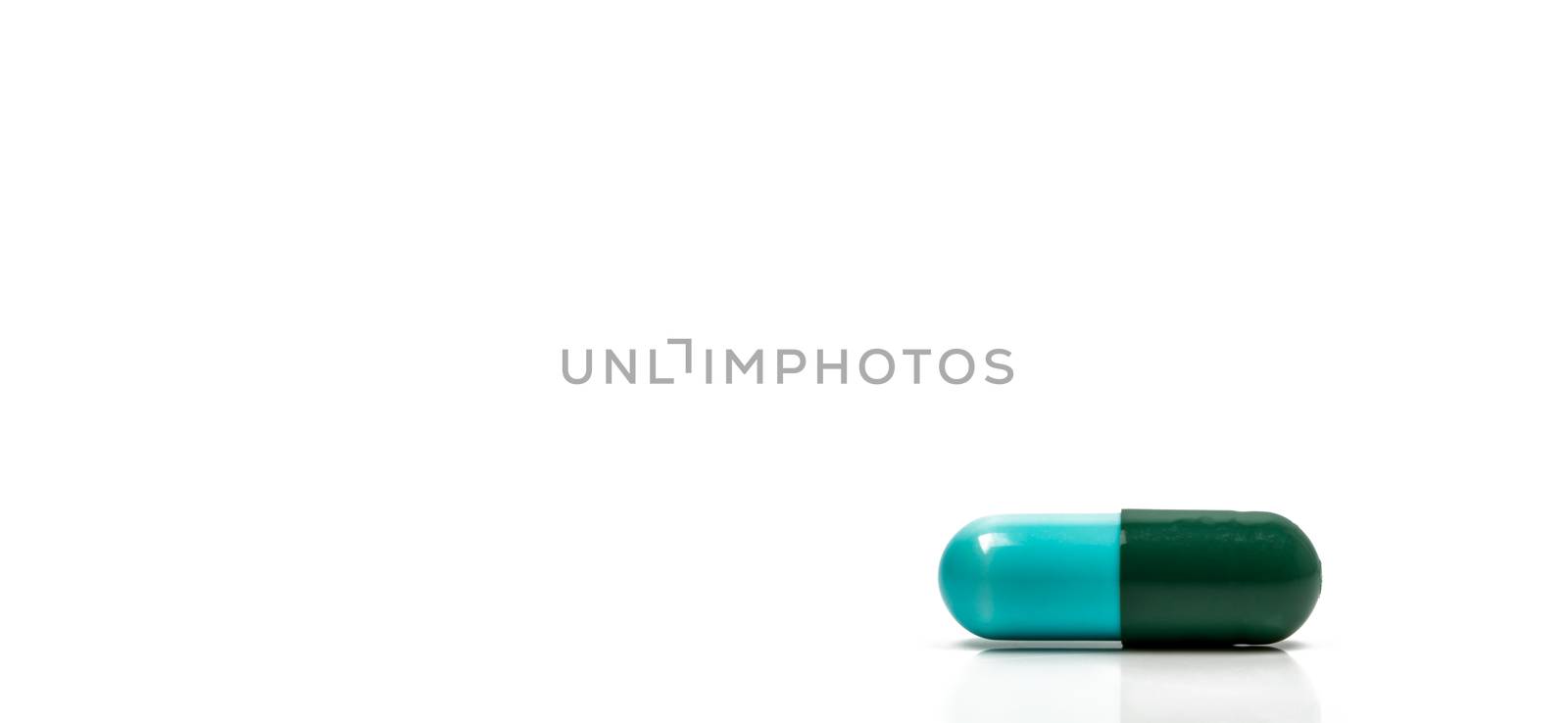 Blue, green antibiotics capsule pill isolated on white background with copy space. Drug resistance concept. Antibiotics drug use with reasonable and global healthcare concept. Pharmaceutical industry. Pharmacy background. by Fahroni
