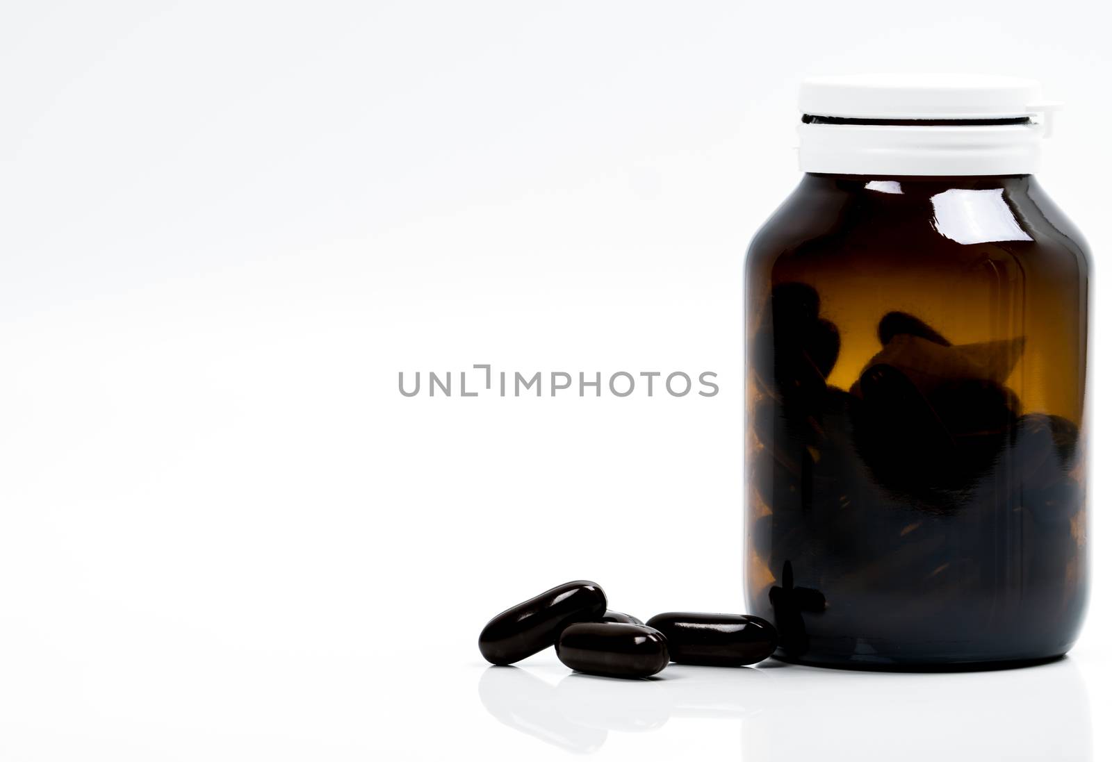 Multivitamins capsule pills for pregnant woman with amber bottle with blank label and copy space isolated on white background. Vitamins and supplements for hard working guy. Global healthcare concept. Pharmaceutical industry. Pharmacy background. Health budgets and policy.