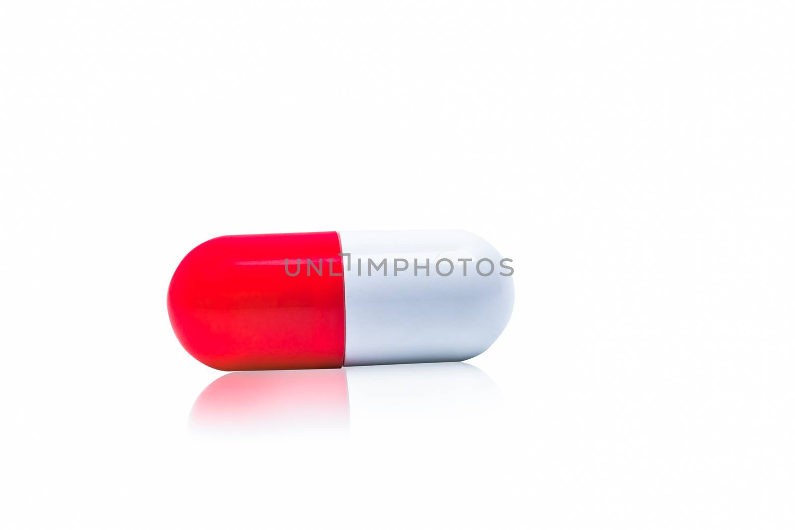 Red, white capsule pills isolated on white background with shadow and copy space for text. Drug resistance concept. Antibiotics drug use with reasonable and global healthcare concept. Pharmacy sign and symbol. Pharmaceutical industry. Pharmacy background. Antibiotic or antimicrobial drug resistance. Health budgets and policy.
