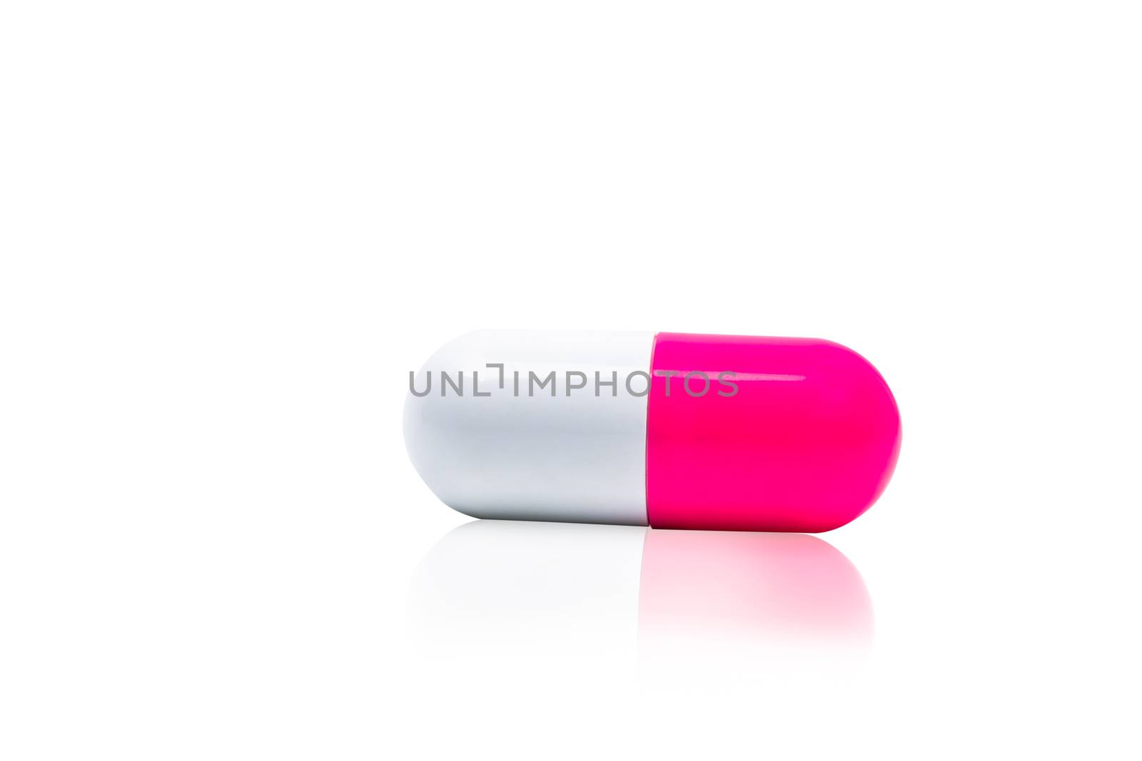 Pink, white capsule pills isolated on white background with shadow and copy space for text. Drug resistance concept. Antibiotics drug use with reasonable and global healthcare concept. Pharmacy sign and symbol. Pharmaceutical industry. Pharmacy background. Antibiotic or antimicrobial drug resistance. Health budgets and policy.