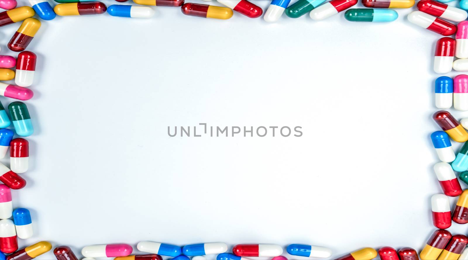 Colorful of antibiotics capsule pills rectangle frame on white background with copy space. Drug resistance concept. Antibiotics drug use with reasonable and global healthcare concept. Pharmacy background. by Fahroni