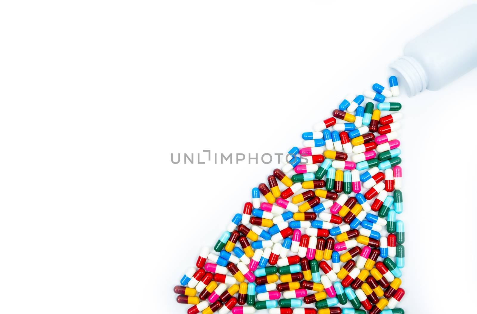 Antibiotic capsules spilling out of pill bottle on white background with copy space, just add your own text. Drug resistance concept. Antibiotics drug use with reasonable and global healthcare concept. Pharmaceutical industry. Pharmacy background.