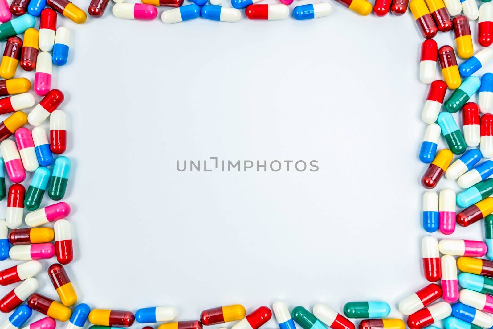 Colorful of antibiotics capsule pills rectangle frame on white background with copy space. Drug resistance concept. Antibiotics drug use with reasonable and global healthcare concept. by Fahroni