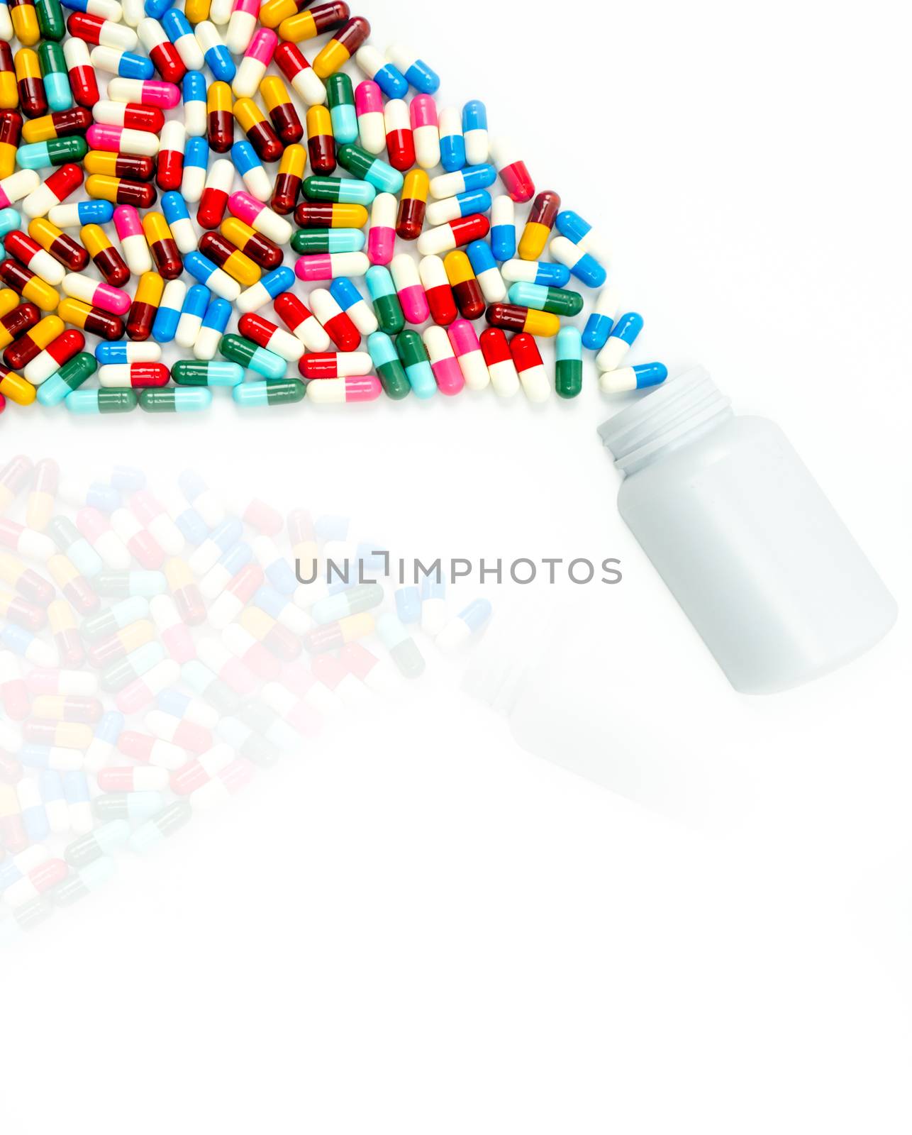 Antibiotic capsules spilling out of pill bottle on white background with copy space and shadows. Drug resistance concept. Antibiotics drug use with reasonable and global healthcare concept. Toxicology.