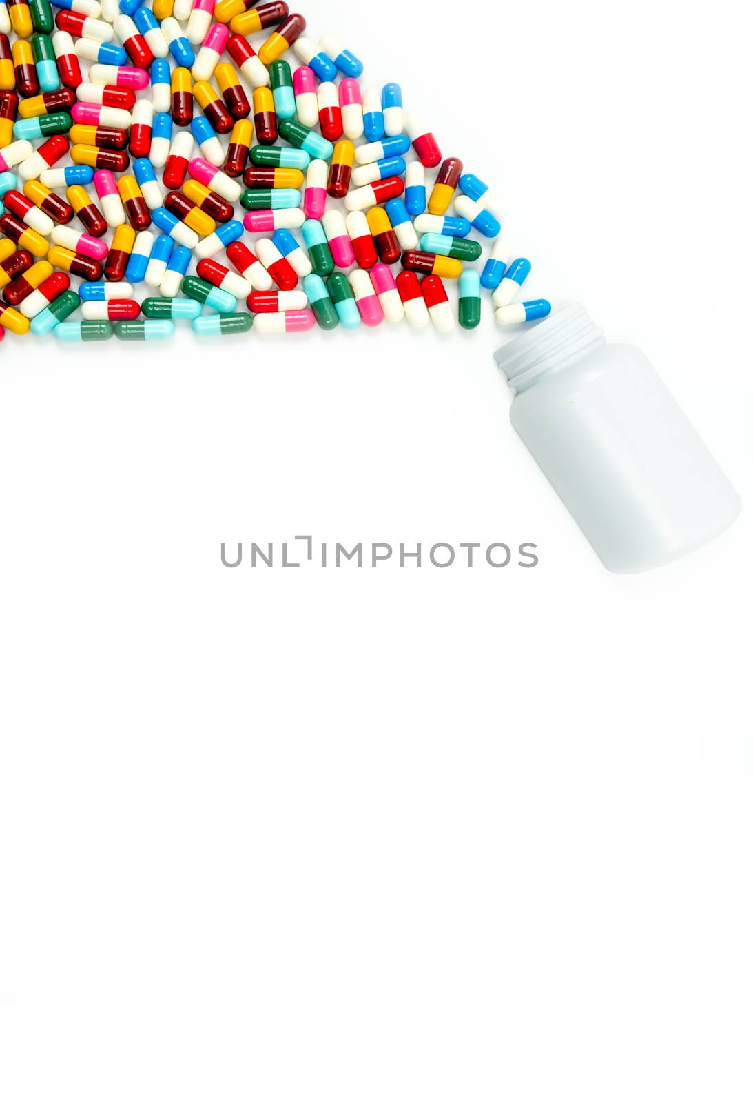 Antibiotic capsules spilling out of pill bottle on white background with copy space, just add your own text. Drug resistance concept. Antibiotics drug use with reasonable and global healthcare concept. Pharmaceutical industry. Pharmacy background.
