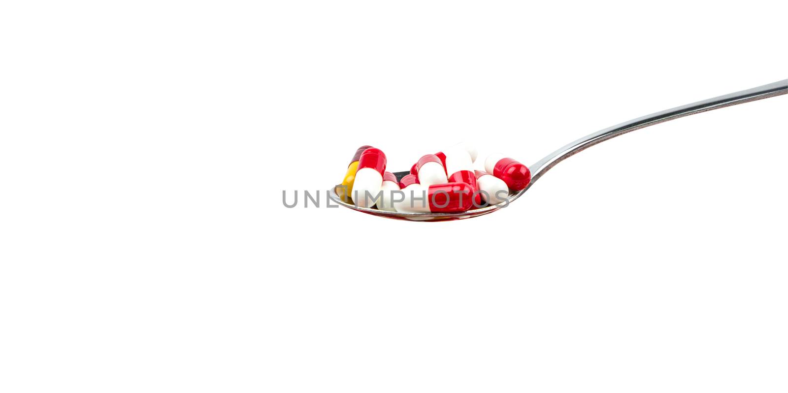 Antibiotic capsule pills in stainless steel spoon isolated on background with copy space. Drug resistance concept. Antibiotics drug use with reasonable and global healthcare concept.