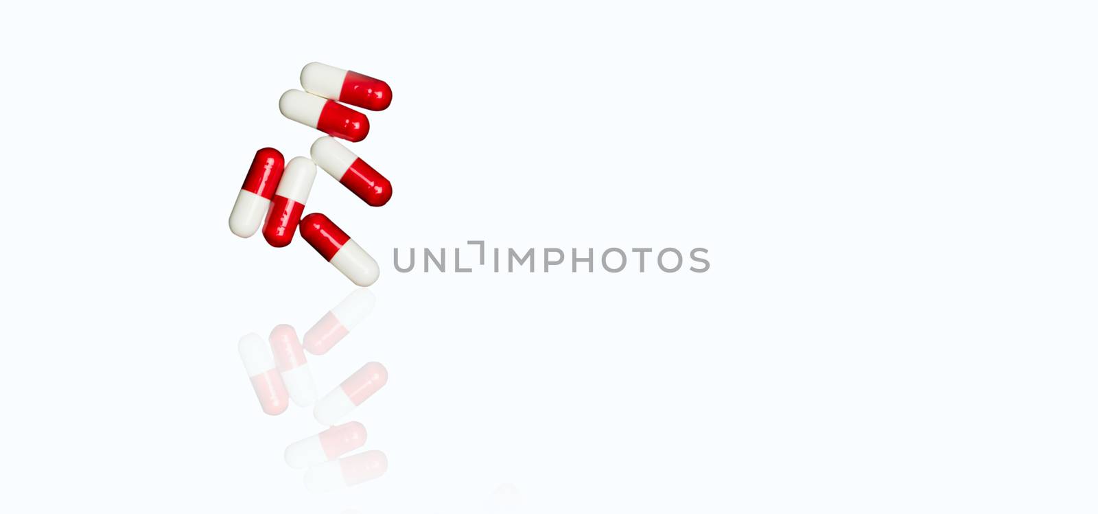 Red, white antibiotic capsules pills isolated on white background with copy space and clipping path. Antimicrobial drug resistance, antibiotic drug use with reasonable concept. Pharmacy background.