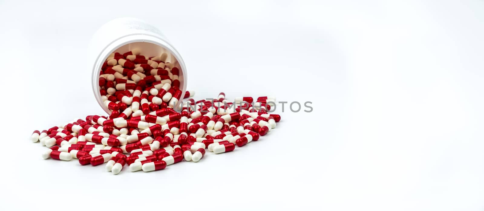 Colorful of antibiotic capsules pills with plastic bottle isolated on white background. Drug resistance, antibiotic drug use with reasonable. Antibiotics drug overuse. Pharmaceutical industry. Pharmacy background. by Fahroni