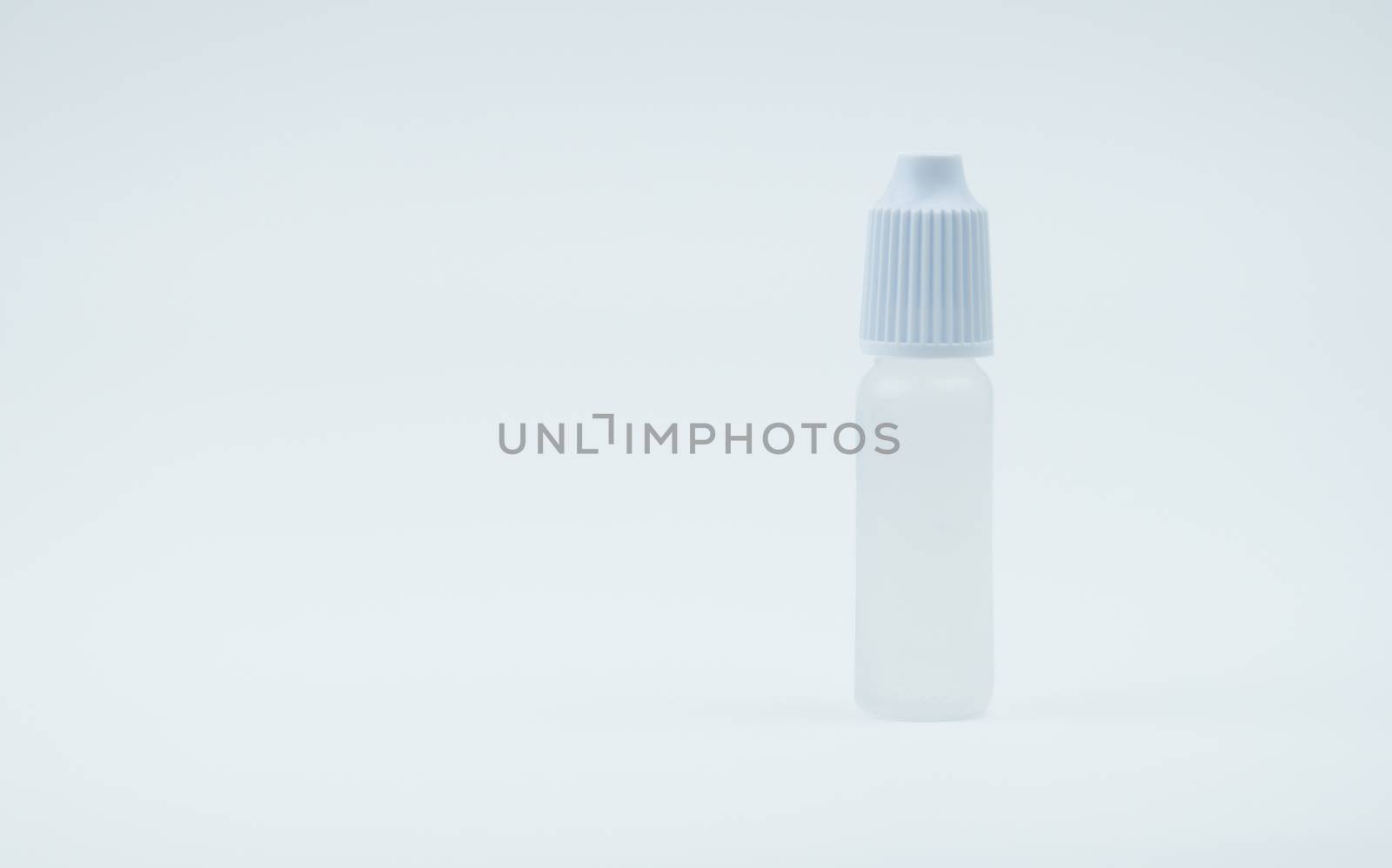 Eye drops bottle with white cap on white background with blank label and copy space, just add your own text. Dry eye disease from smartphone use, digital screen. digital eye strain.