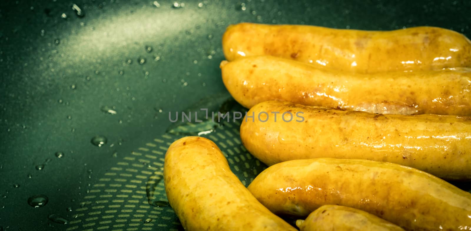 Fried pork sausage in a pan. Unhealthy food. Food cause of colon and rectal cancer. by Fahroni