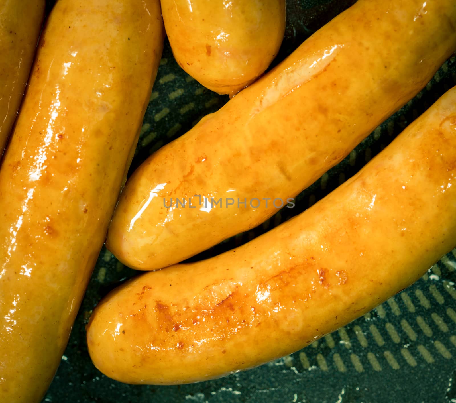 Fried pork sausage in a pan. Unhealthy food. Food can cause rectal and colon cancer.
